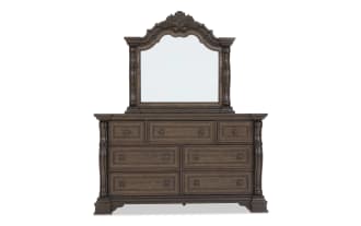 Traditional dark brown wooden dresser with ornate carved details, six large drawers, three smaller drawers, and a matching decorative mirror.