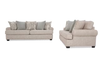 Beige fabric sofa with rolled arms and dark wooden legs, featuring six decorative cushions in paisley and solid gray patterns, shown from front and side angles.