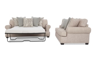 Beige fabric sofa bed with rolled arms, dark wooden legs, and patterned and solid throw pillows, shown open and from side.