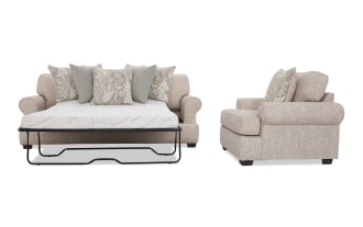 Beige fabric sleeper sofa with rolled arms, patterned and solid throw pillows, shown in open bed and side chair view.