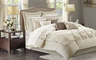 Alan Queen Ivory Solid 24 Piece Comforter Set in contemporary beige and brown polyester fabric, featuring a plush comforter, multiple decorative pillows, Euro and standard shams, sheets, bed skirt, window valances, and tiebacks for a complete bedroom makeover.