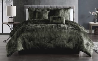 Luxurious dark green crushed velvet comforter set on a modern bed with matching pillows, showcasing soft texture and elegant bedroom decor.