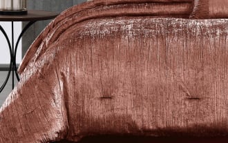 Luxurious crushed velvet rose gold comforter set with matching decorative pillows on a modern bed, highlighting soft texture and elegant bedroom decor.