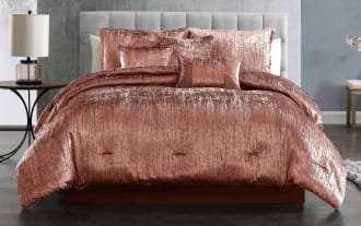 Luxurious crushed velvet rose gold comforter set with matching decorative pillows on a modern bed, highlighting soft texture and elegant bedroom decor.