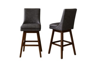 Set of two modern bar stools with dark gray leather cushioned seats and backs, supported by sturdy brown wooden legs with footrests.