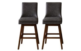 Set of two modern bar stools with dark gray leather cushioned seats and backs, supported by sturdy brown wooden legs with footrests.