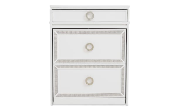 White wooden nightstand with three drawers featuring silver ring handles and decorative silver trim, modern bedroom furniture design.