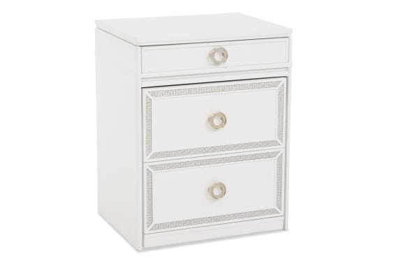 White wooden nightstand with three drawers featuring silver ring handles and decorative silver trim, ideal for bedroom storage.