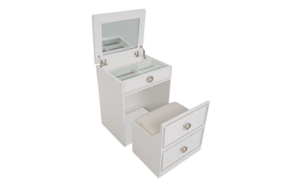White wooden vanity table with cushioned stool, featuring a top mirror, glass-covered storage compartments, and two drawers with silver handles.