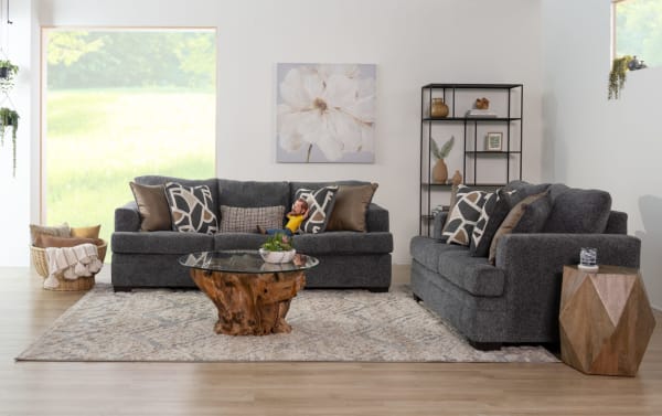 Transitional living room with gray fabric polyester sofas from Hannah collection, featuring plush cushions, geometric pillows, a wooden coffee table, and modern decor.
