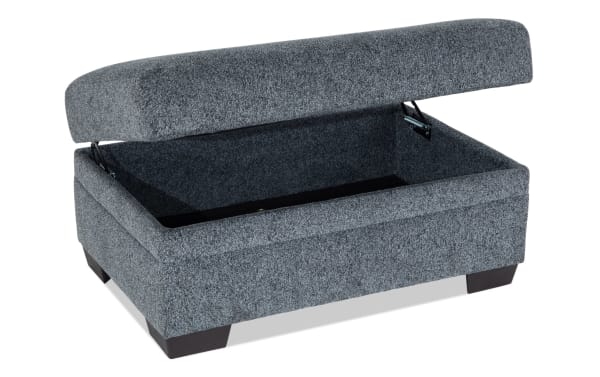Hannah Gray Storage Ottoman in transitional style with plush gray polyester fabric, cushioned top, and hidden storage compartment.