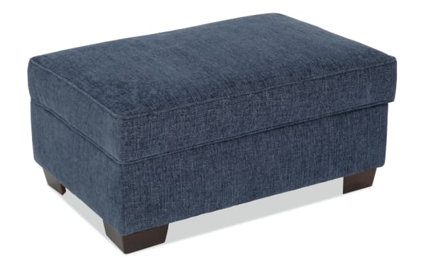 Brynn Navy Storage Ottoman in transitional style, upholstered in soft navy polyester fabric with cushioned top and hidden storage space.