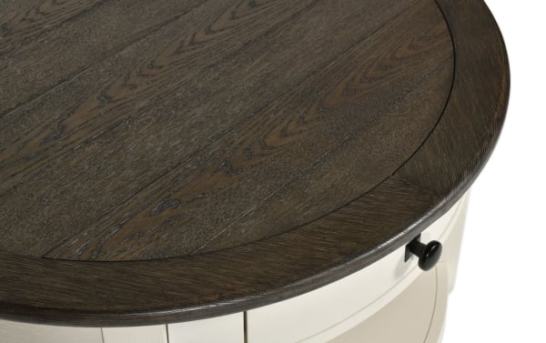 Round farmhouse-style Laurel White & Brown Storage Coffee Table with distressed dark wood MDF top, light painted base, and black drawer knob for storage.