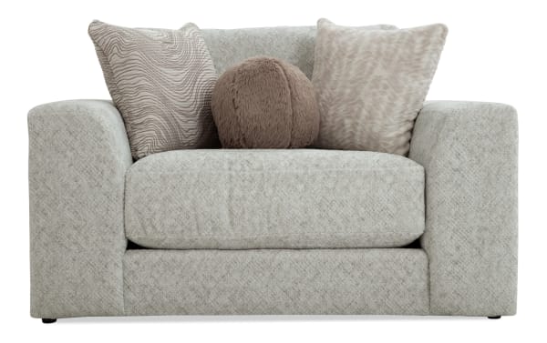 Modern beige fabric loveseat with thick cushioned arms, plush seat, and three decorative soft textured throw pillows in neutral tones.