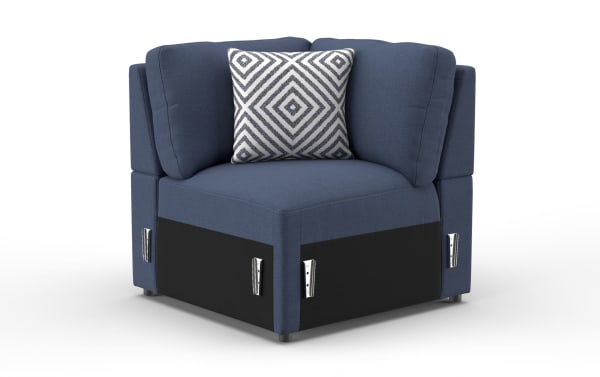 Blue fabric corner chair with plush cushions, black base panels, and a decorative white pillow featuring a gray geometric diamond pattern.