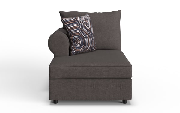 Dark gray fabric chaise lounge with a rounded left armrest, matching back cushion, and a decorative geometric patterned throw pillow.