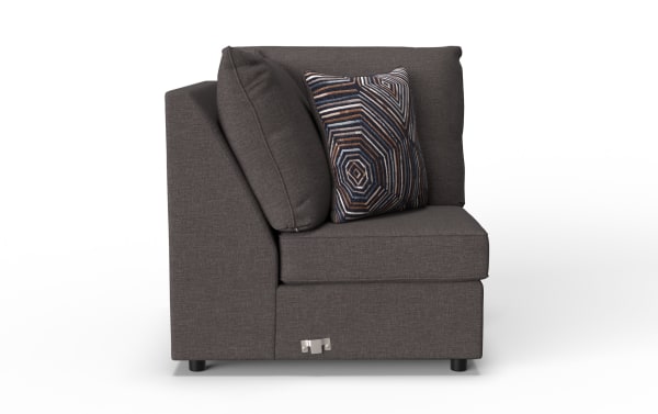 Dark gray fabric corner sofa section with cushioned backrest and armrest, featuring a decorative geometric-patterned throw pillow.