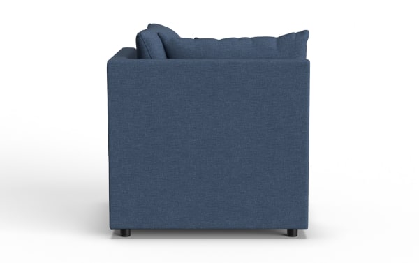Dark blue fabric sofa side view showing clean lines, square armrest, and cushioned backrest with matching pillows on black legs.