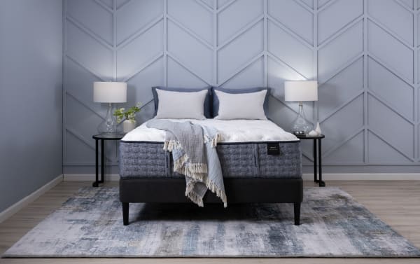 Envy 15.5'' Twin XL Firm Mattress in gray and white with hand-tufted Tencel knit cover, gel memory foam, and 2,000 micro coils on black bed frame.