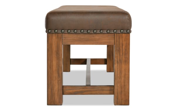 Rustic Tahoe Brown Upholstered Bench with solid pine legs and brown faux leather seat, featuring nailhead trim and memory foam cushioning.