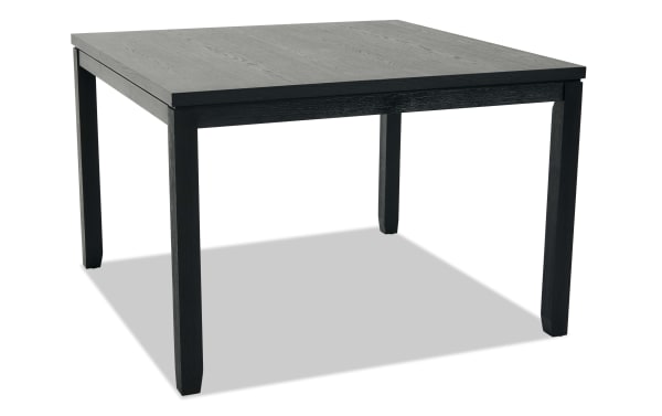 Square black wooden dining table with a smooth tabletop and four sturdy legs, suitable for modern home or office use.