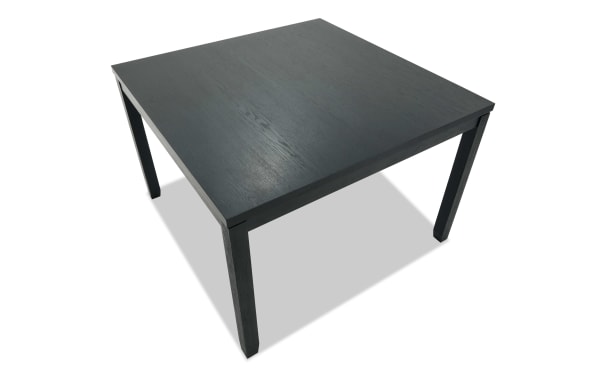 Square black wooden table with a smooth surface and four sturdy legs, suitable for dining or office use.