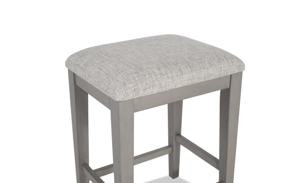 Gray Homeworks Dining backless counter height stool with cushioned polyester fabric seat, wooden frame with melamine, MDF, and rubberwood solids.