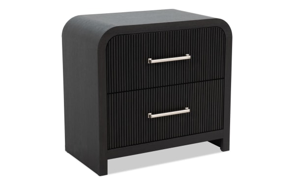 Cascade Black 2 Drawer Nightstand from Cascade Bedroom collection, transitional style in black engineered wood grain with reeded drawer fronts, rounded corners, and sleek metal handles.
