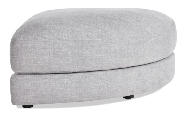 Gravity Gray Curved Ottoman in contemporary style, upholstered in soft gray polyester fabric with a plush, rounded design from the Gravity collection.