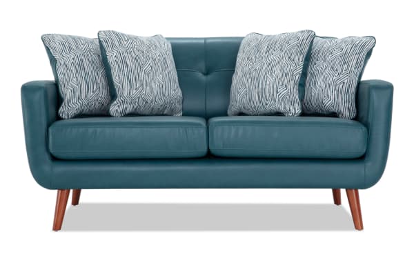 Bettie Teal Faux Leather 65'' Loveseat in mid-century modern style with teal faux leather upholstery, four patterned fabric accent pillows, tufted back, track arms, and wooden tapered legs.