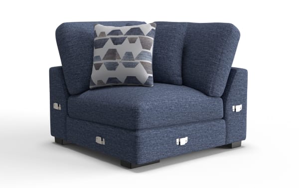 Blue fabric corner sofa chair with dark wooden legs, featuring two large back cushions and a geometric patterned throw pillow.