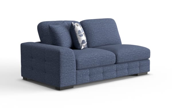 Blue fabric loveseat with tufted sides and base, featuring two large cushions and one patterned accent pillow, modern design.