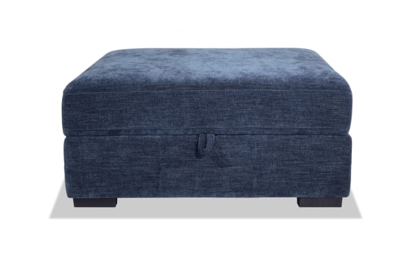 Contemporary Playground Navy Storage Ottoman in blue polyester fabric with plush memory foam seating, hand-tufted detailing, and hidden storage space.
