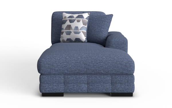 Blue fabric chaise lounge with textured upholstery, featuring two decorative pillows—one with geometric patterns and one solid blue.