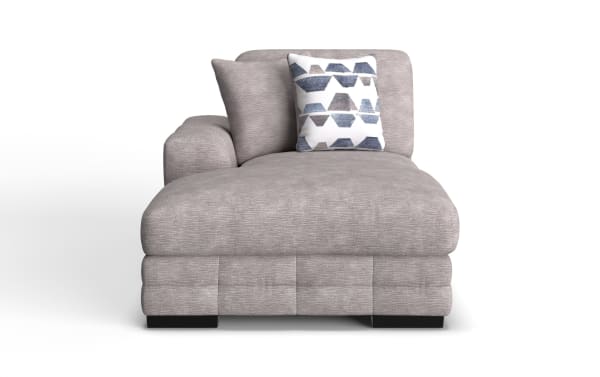 Gray upholstered chaise lounge with a soft textured fabric, featuring a single armrest on the left, two matching back cushions, and a decorative white pillow with blue geometric patterns.