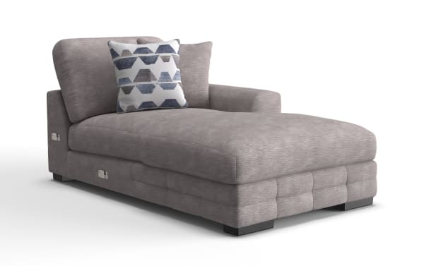 Gray fabric chaise lounge with soft cushioning, tufted base, one armrest, and a decorative geometric-patterned pillow, ideal for modern living rooms.
