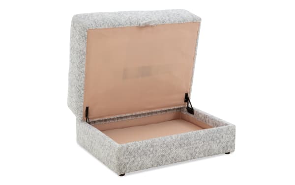 Upholstered storage ottoman with light gray textured fabric, hinged lid revealing spacious beige interior for organizing items.