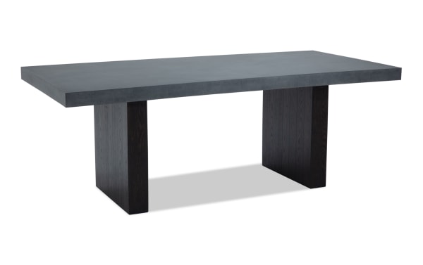 Rectangular modern dining table with a thick dark gray concrete top and two wide black wooden pedestal legs, suitable for contemporary interiors.