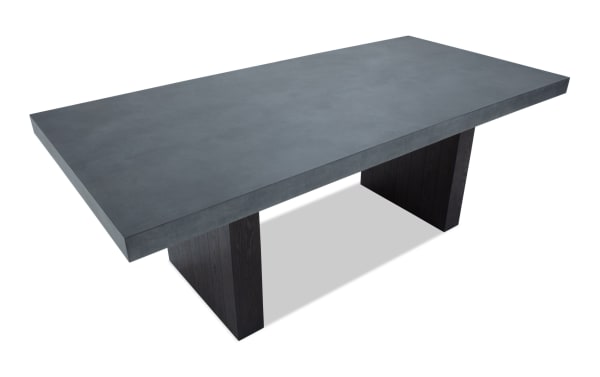 Rectangular modern dining table with a thick dark gray concrete top and two wide black wooden pedestal legs, suitable for contemporary interiors.