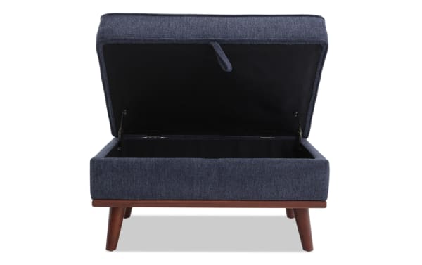 Tribeca Navy Storage Ottoman in mid-century modern style, navy polyester fabric upholstery, memory foam cushioning, and hidden storage compartment.