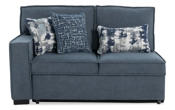 Blue upholstered sectional sofa with two seat cushions, two back cushions, and three decorative patterned throw pillows in navy and white.