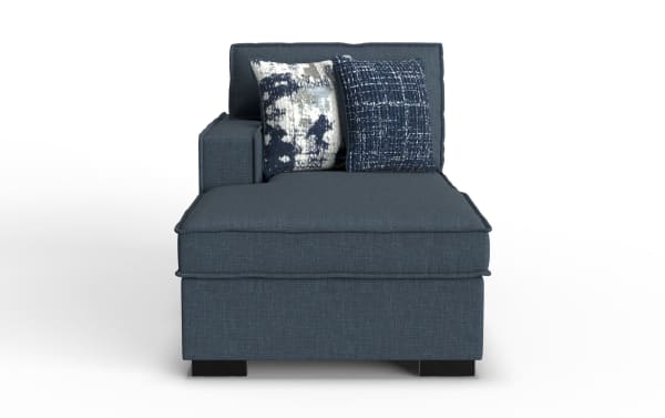 Modern blue fabric chaise lounge with two patterned throw pillows, featuring a cushioned backrest and armrest on the left side.