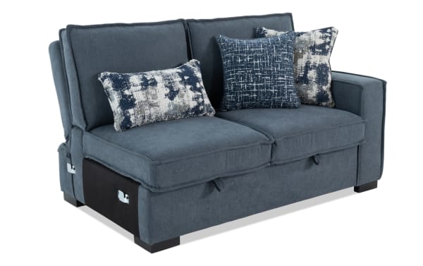 Blue fabric loveseat sofa with thick cushions, three decorative blue and white patterned pillows, and black wooden block legs.