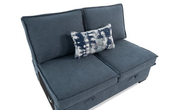 Blue fabric loveseat sofa with two large back cushions and a patterned rectangular throw pillow, featuring modern design and plush seating.