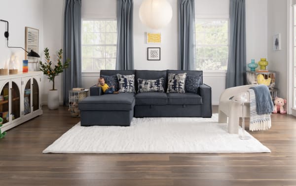 Transitional Playmax Denim Chaise Lounge in blue polyester fabric with memory foam seating, accent pillows, and spacious L-shape design on a white rug.
