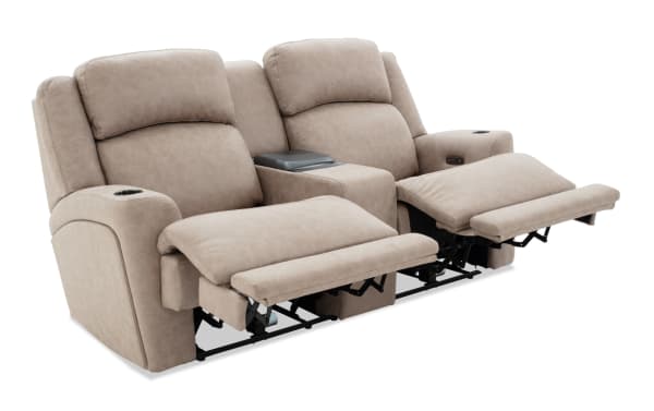 Beige leather dual recliner loveseat with cup holders, center console storage, and padded footrests, designed for home theater comfort.