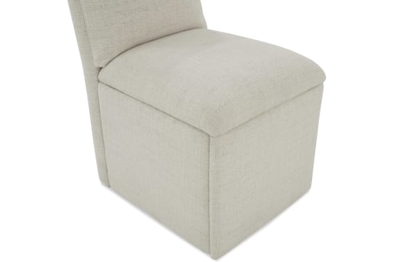 Beige upholstered storage ottoman chair with textured fabric, cushioned seat, and compact design for living room or bedroom seating and storage.