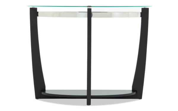 Modern round side table with clear glass top, black curved legs, and lower black shelf, suitable for living room or office decor.