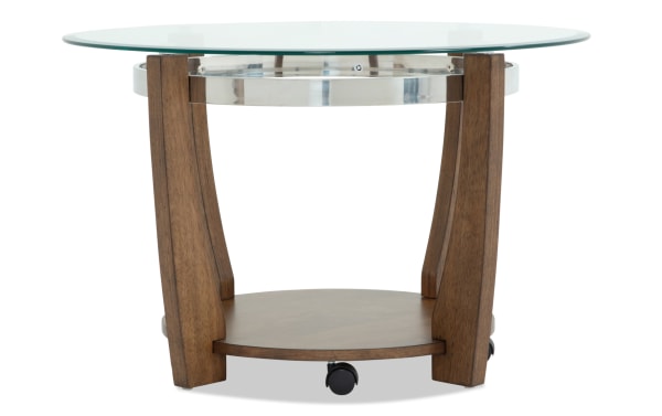 Round modern side table with a clear glass top, walnut wood legs, a lower wooden shelf, and a chrome metal ring detail.