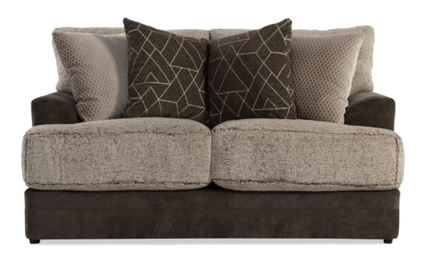 Two-seater sofa with plush beige sherpa cushions, dark brown microfiber base and armrests, and four decorative throw pillows with geometric and honeycomb patterns.